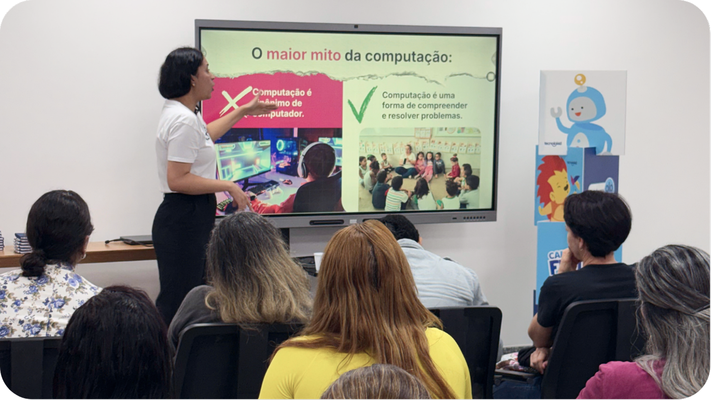 Formadora apresentando uma formação para uma plateia de professores