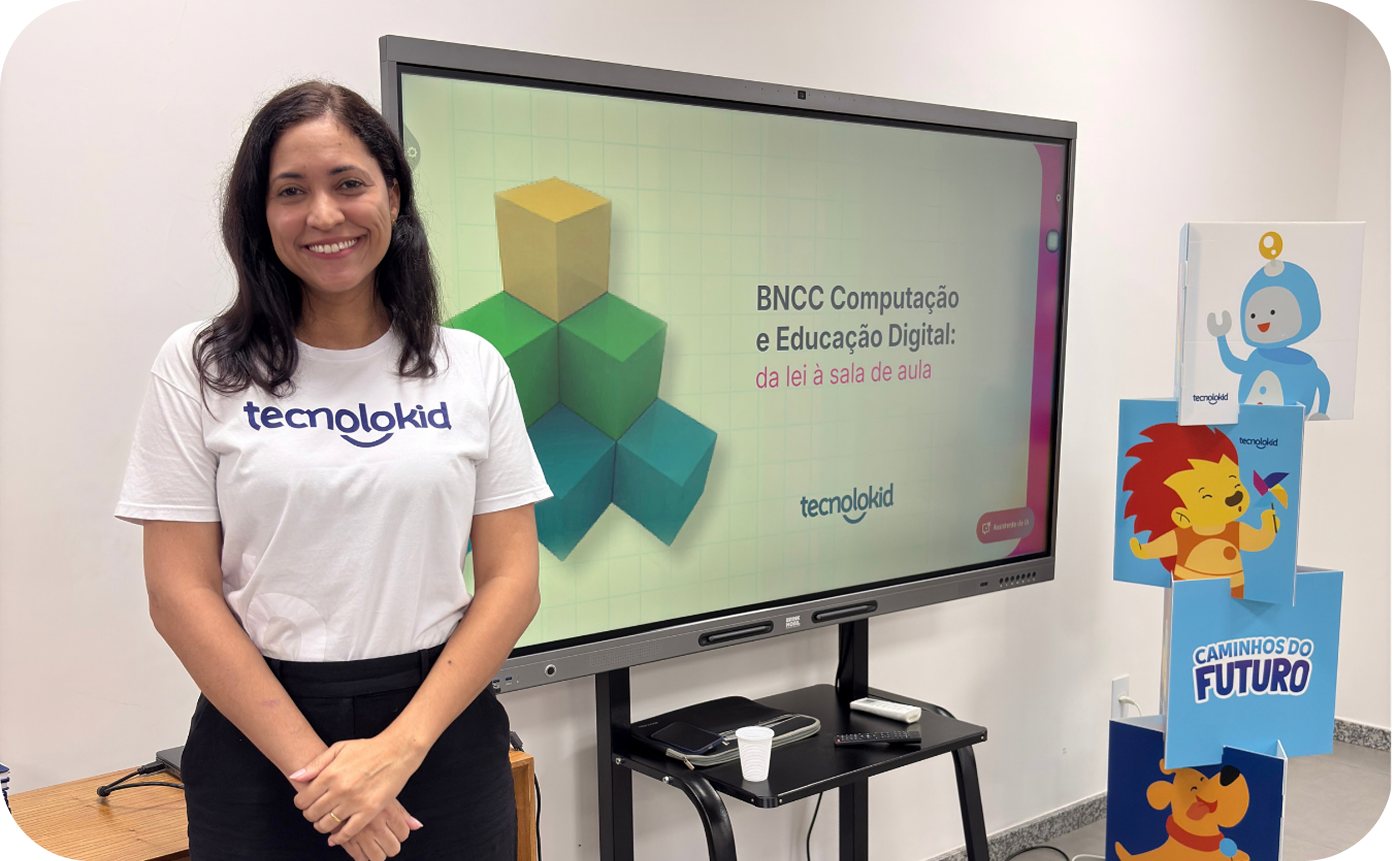 Formadora da Tecnolokid em frente a uma tela interativa com o tema BNCC Computação e Educação Digital