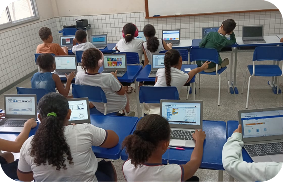 Alunos em sala de aula fazendo atividades de programação em blocos da Plataforma OLO nos notebooks